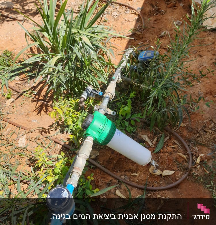 צינור מים עם מסנן ומד מים בגינה